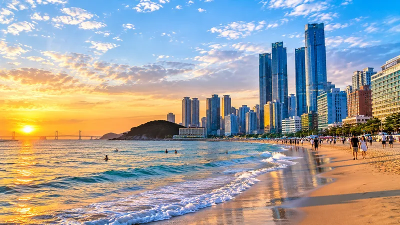 Haeundae Beach at sunset with Busan's skyline